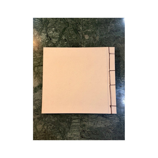 Contracubierta lisa de papel rosa pálido con costura visible del libro de artista
