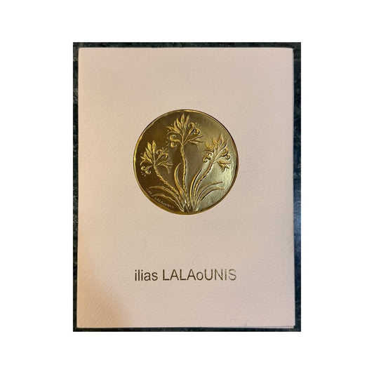 Tarjeta coleccionable Ilias LALAoUNIS con placa dorada en relieve y flores de inspiración griega