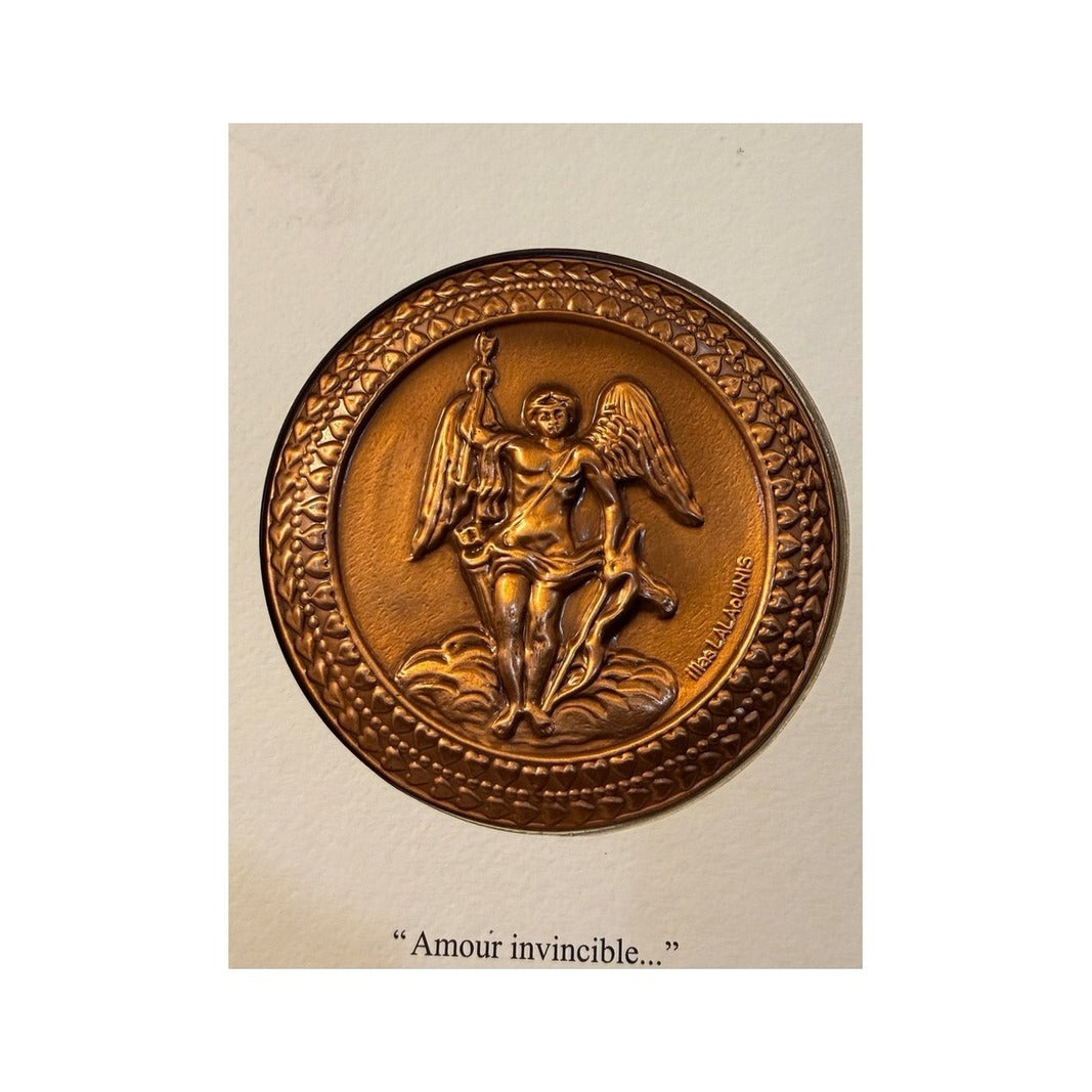 Placa circular cobriza con Eros alado y borde decorado con hojas en relieve