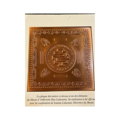 Placa cuadrada cobriza con grecas griegas, rosetas y emblema central de Ilias LALAoUNIS
