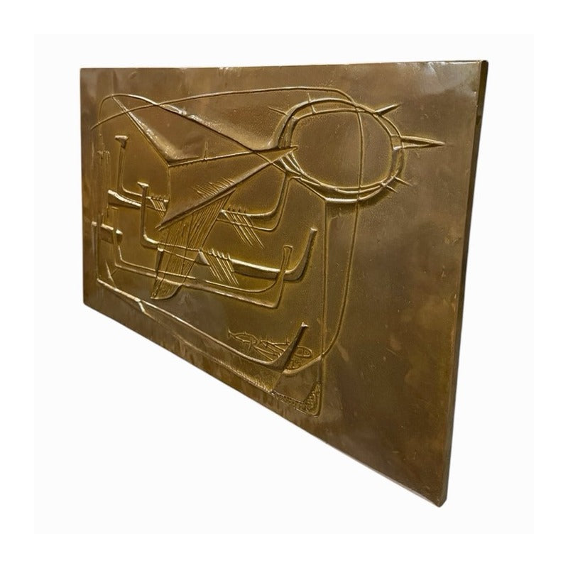 Vista oblicua del panel mid-century de metal dorado con relieve geométrico y composición de barcos estilizados