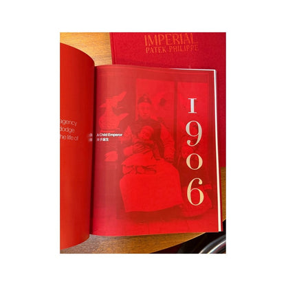 Catálogo Patek Philippe abierto en capítulo sobre el emperador niño, con diseño editorial rojo y texto bilingüe