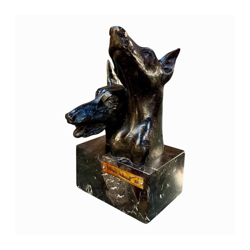 Escultura de bronce de dos cabezas de dóberman sobre base de mármol, vista en ángulo con placa de edición XVI