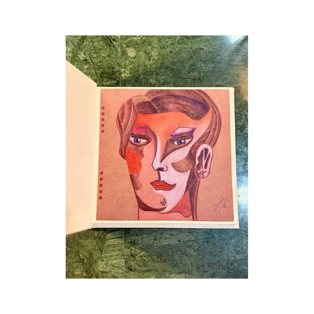 Libro abierto con retrato cubista en tonos coral, rosa y violeta sobre papel artesanal