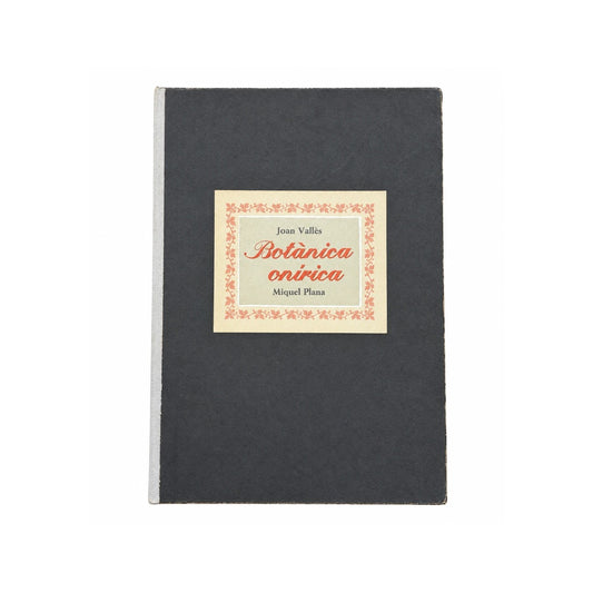 Libro de artista Botànica onírica con cubierta antracita, lomo claro y etiqueta botánica central