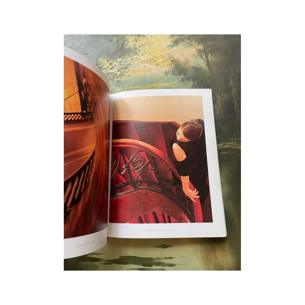 Interior del portafolio fotográfico con mujer junto a una escalera curva roja y otra imagen cálida