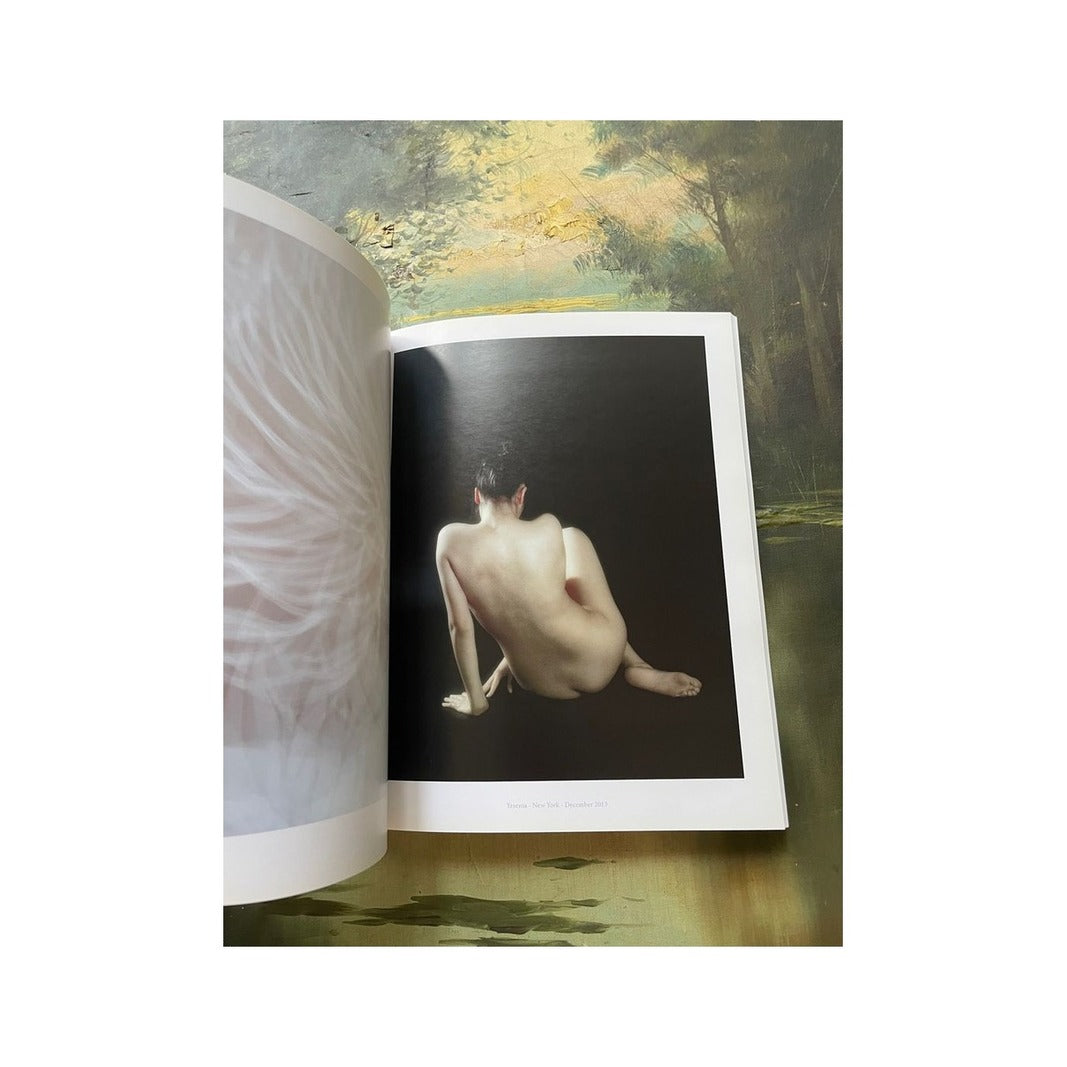 Página interior con fotografía artística de una figura desnuda de espaldas sobre fondo negro y amplios márgenes blancos