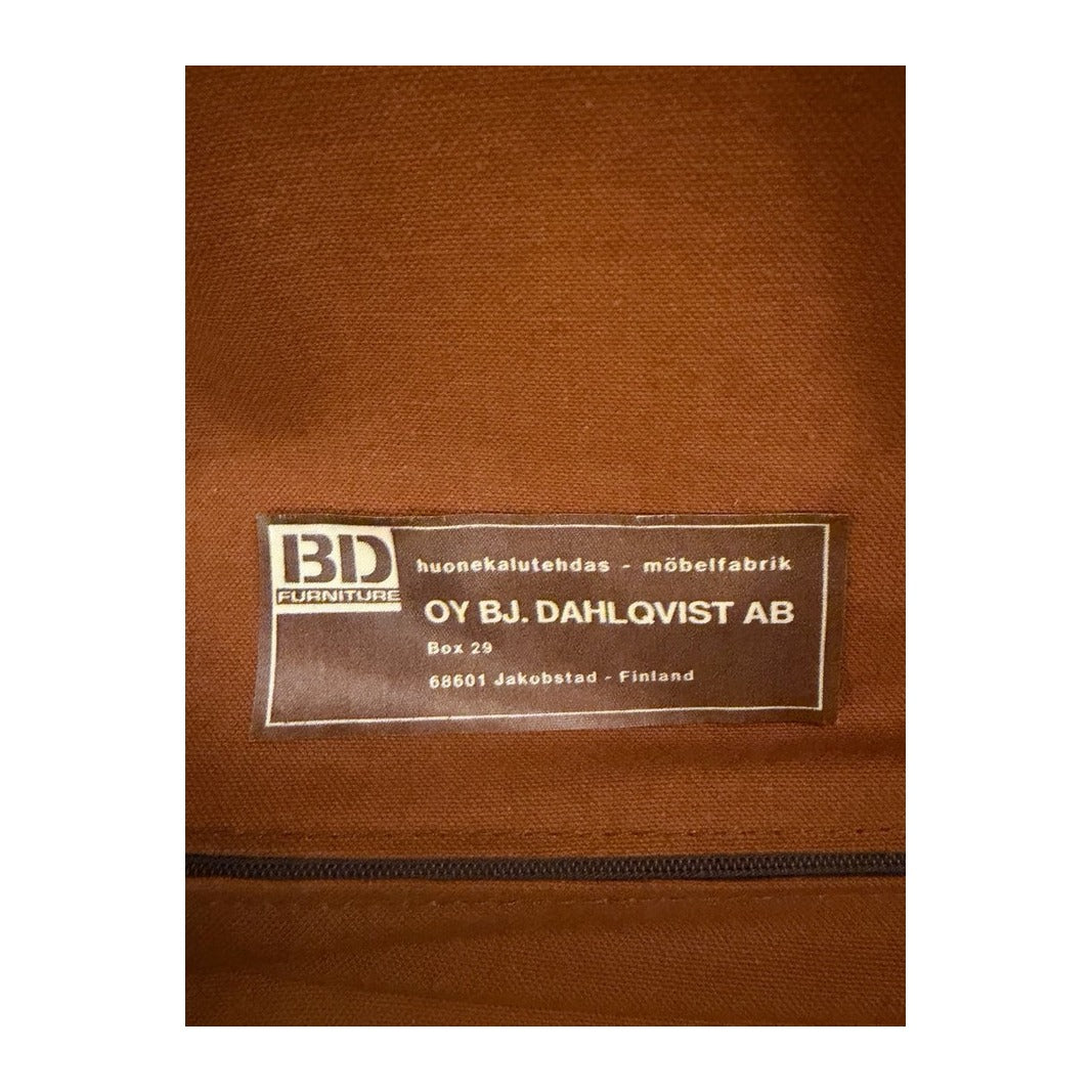 Detalle de la tapicería de tela marrón en el reverso de la butaca, con etiqueta cosida