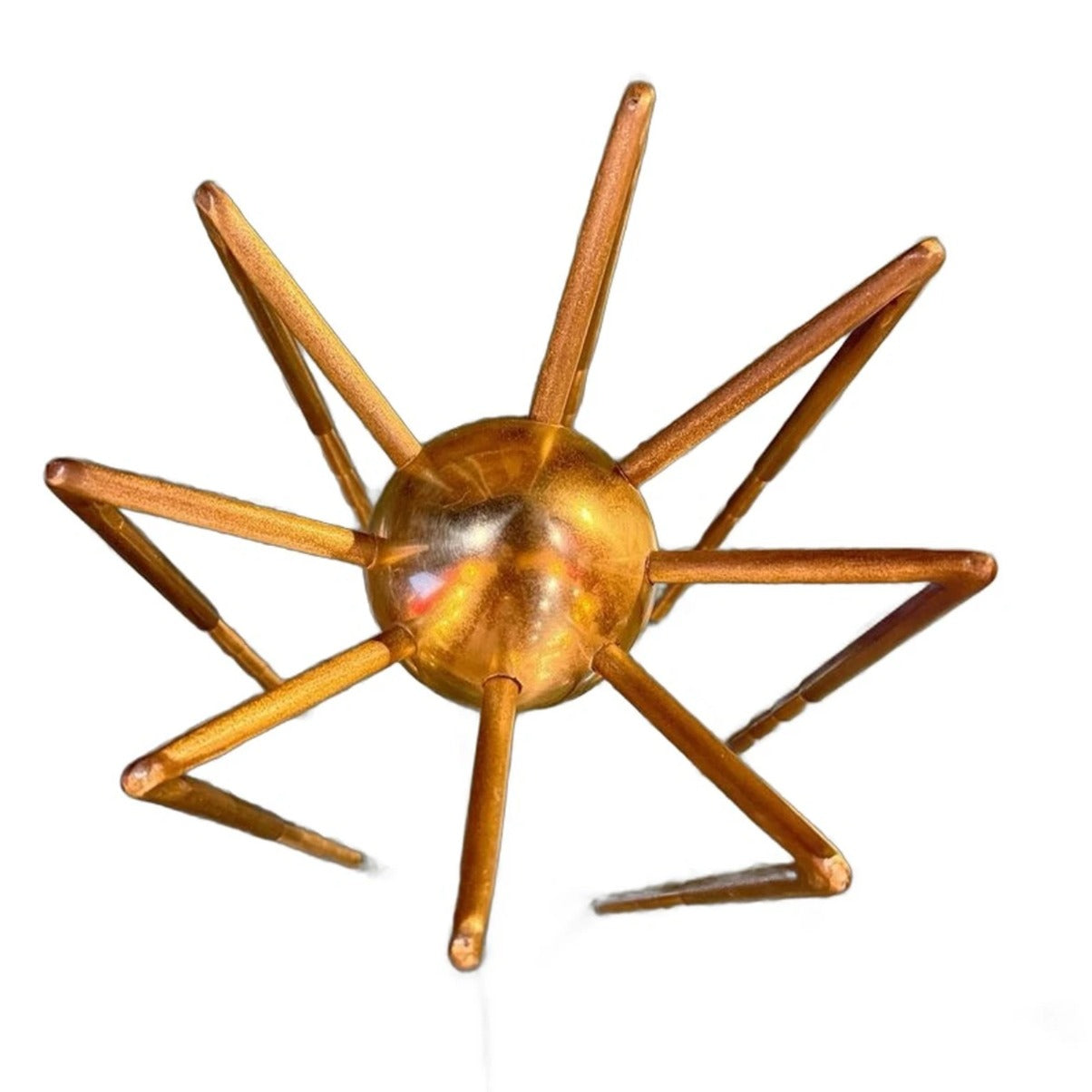 Vista superior de escultura araña dorada mostrando cuerpo esférico y patas radiantes