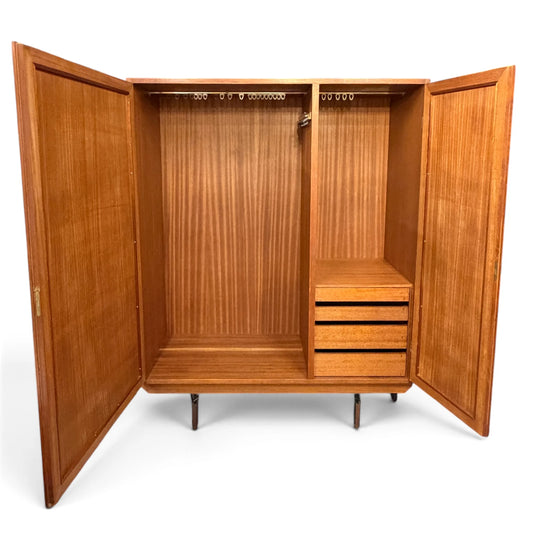 Interior del armario vintage de madera con puertas abiertas, cajones y compartimentos para ropa