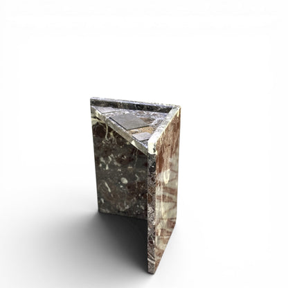 Detalle de pilar de soporte L-shaped de mesa de mármol y superficie con parche gris distintivo