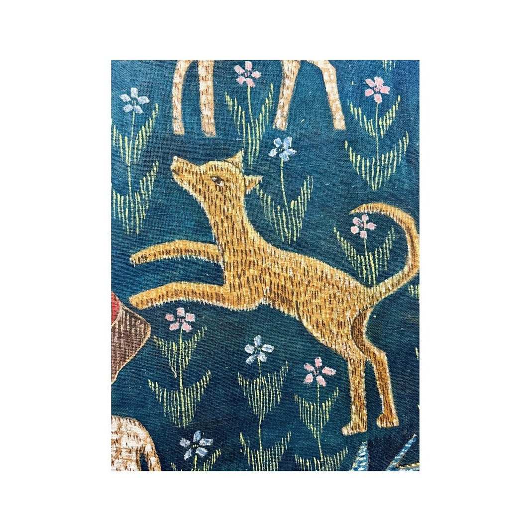 Detalle del tapiz Millefleurs con animal dorado entre flores sobre fondo azul oscuro