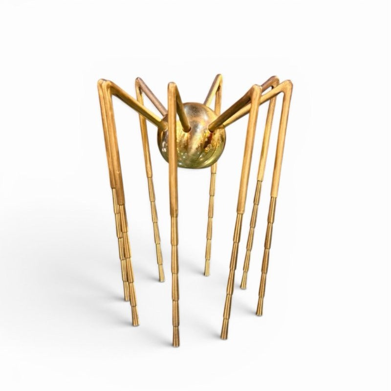Escultura araña dorada de latón con patas largas estilo Mid-Century Modern sobre fondo blanco