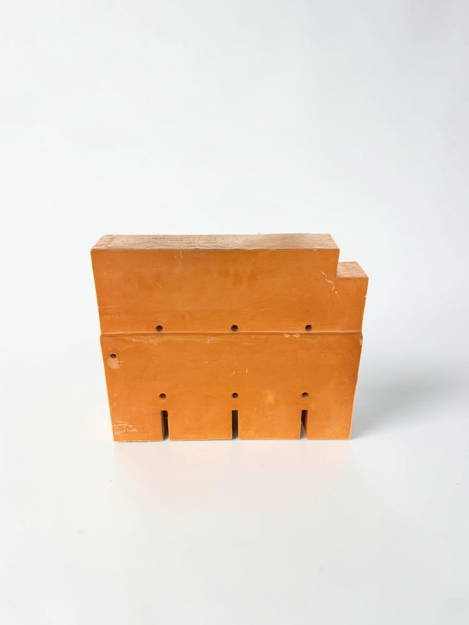 Vista frontal de escultura de terracota geométrica con perforaciones por Perejaumevv