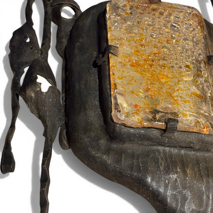 La Basilica Galeria Brutalist wall sconce with hand-welded dark metal frame and amber bubble glass.
