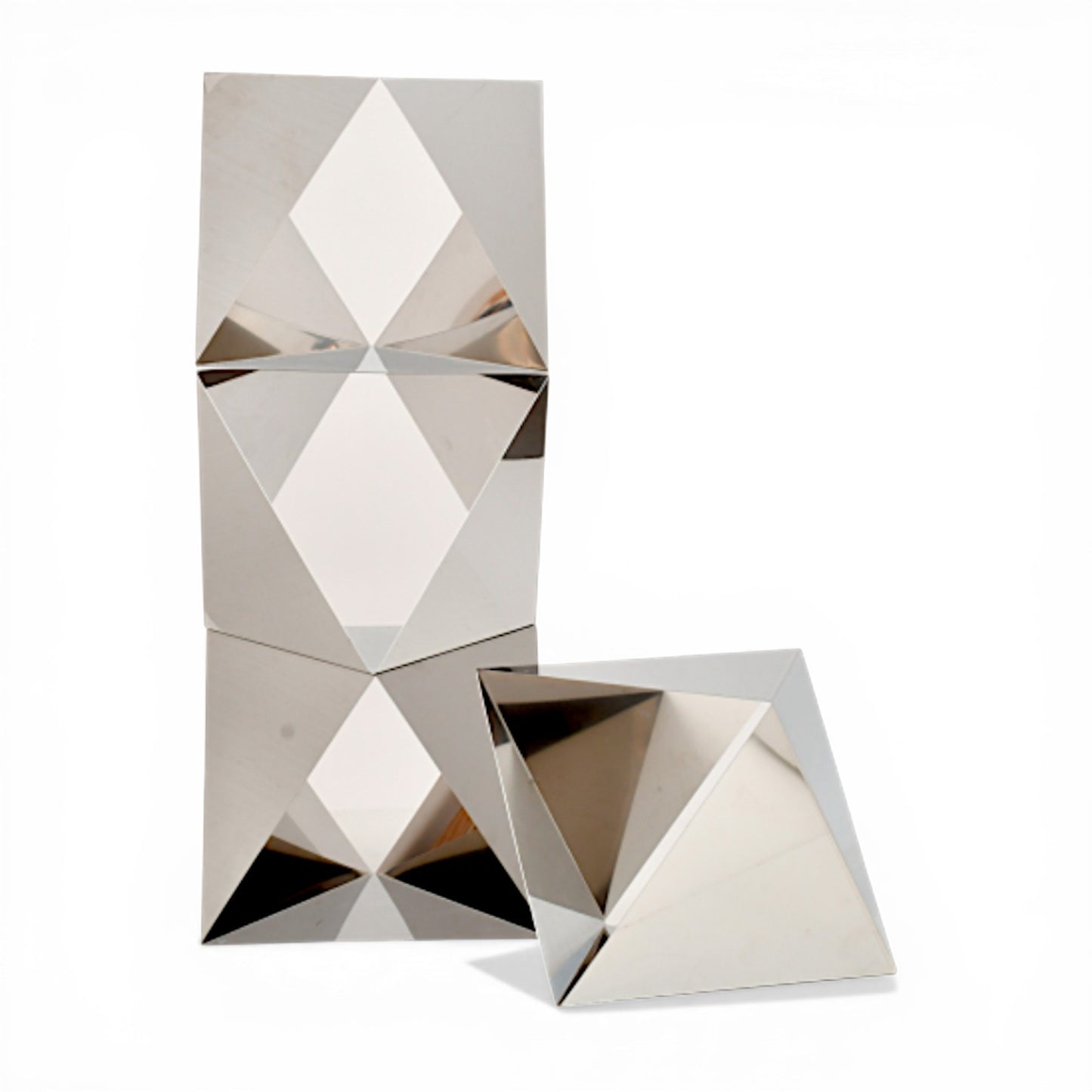 Escultura modular de cuatro piezas de acero pulido espejo con formas geométricas angulares diseñadas por Manfredo Massironi